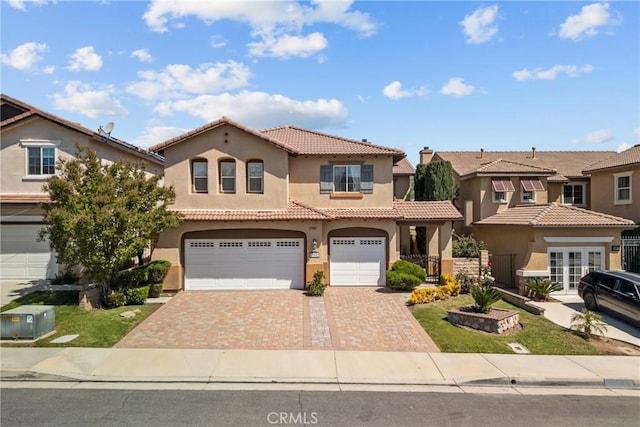 29081 Madrid Pl, Castaic, CA 91384 - mediterranean / spanish-style home with stucco siding, a tile roof, an attached garage, decorative driveway, and french doors