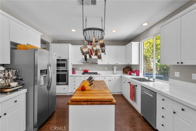 29081 Madrid Pl, Castaic, CA 91384 - kitchen featuring appliances with stainless steel finishes, a sink, a kitchen island, wooden counters, and white cabinetry