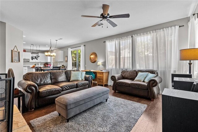 living area with recessed lighting, ceiling fan with notable chandelier, and dark wood-style floors