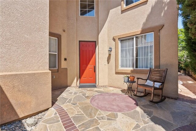 entrance to property with a patio and stucco siding