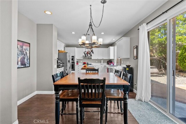 dining area with baseboards, recessed lighting, dark wood-style flooring, and a chandelier