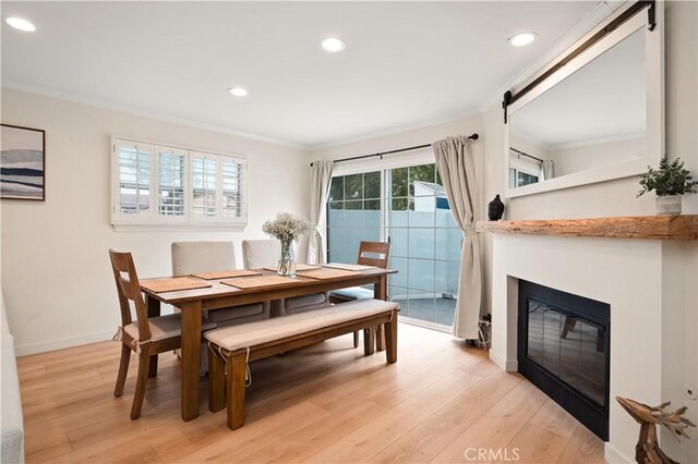 dining room featuring crown molding, recessed lighting, baseboards, and light wood-style flooring