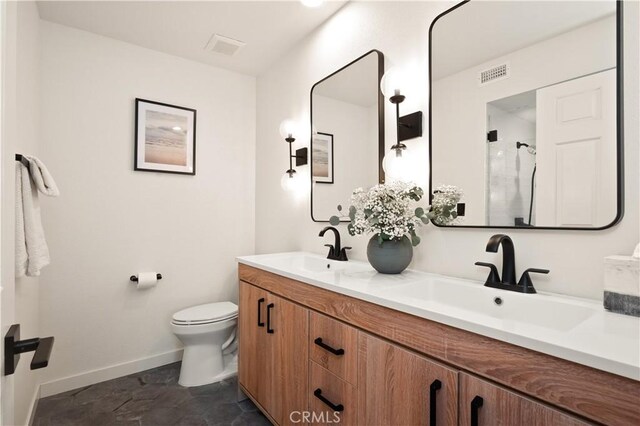 bathroom featuring visible vents, a sink, baseboards, and toilet
