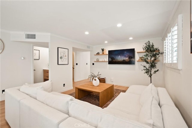 living room with light wood-style floors, recessed lighting, baseboards, visible vents, and ornamental molding