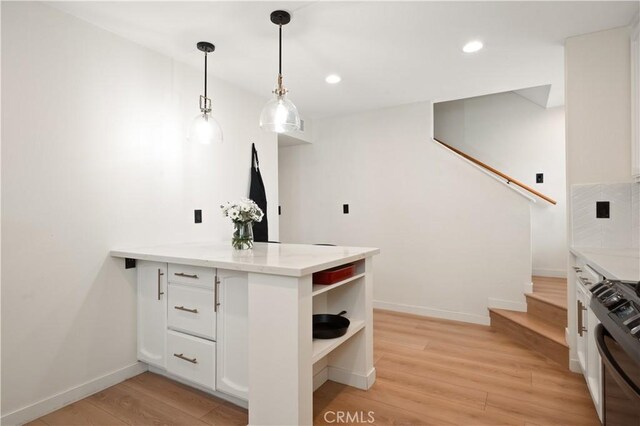 kitchen with white cabinets, open shelves, black gas range oven, light wood finished floors, and a peninsula