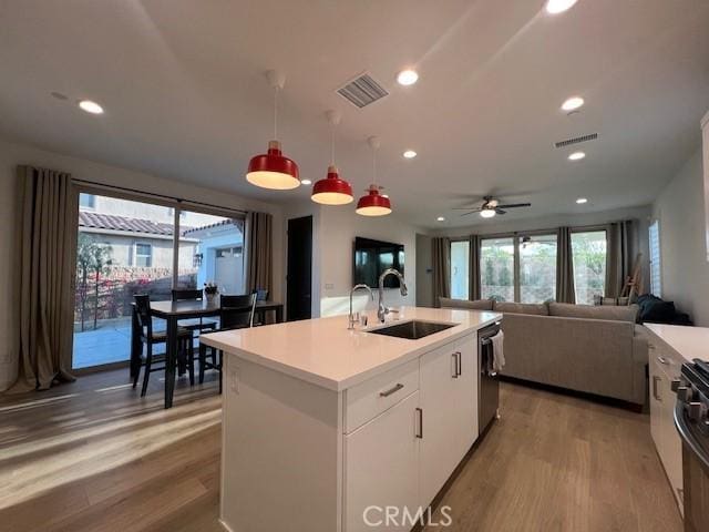 35719 Mccarthy St, Palm Desert, CA 92211 - kitchen with a sink, light wood finished floors, dishwasher, light countertops, and visible vents