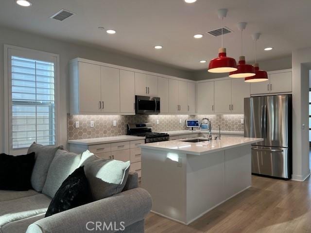 35719 Mccarthy St, Palm Desert, CA 92211 - kitchen with appliances with stainless steel finishes, a sink, light countertops, light wood-type flooring, and visible vents