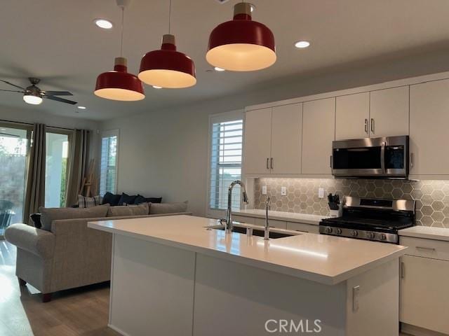 35719 Mccarthy St, Palm Desert, CA 92211 - kitchen featuring plenty of natural light, backsplash, appliances with stainless steel finishes, a sink, and light wood-style flooring