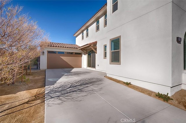 35719 Mccarthy St, Palm Desert, CA 92211 - view of property exterior featuring a tiled roof, a garage, stucco siding, and driveway