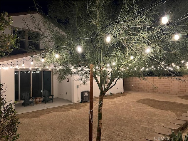 35719 Mccarthy St, Palm Desert, CA 92211 - back of house at night with fence, central AC unit, stucco siding, and a patio area
