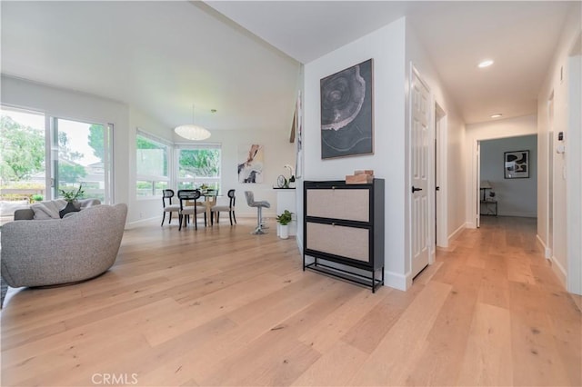 hall with light wood-style floors, baseboards, and recessed lighting