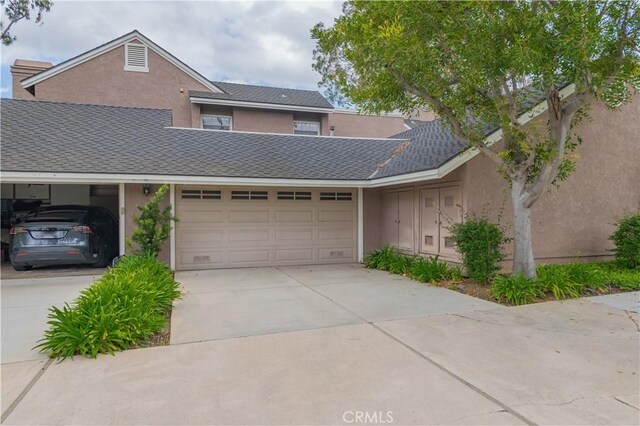 townhome / multi-family property featuring concrete driveway, an attached garage, and stucco siding