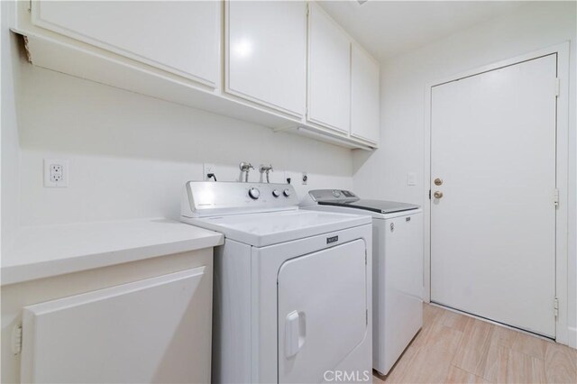 washroom featuring cabinet space and washer and dryer