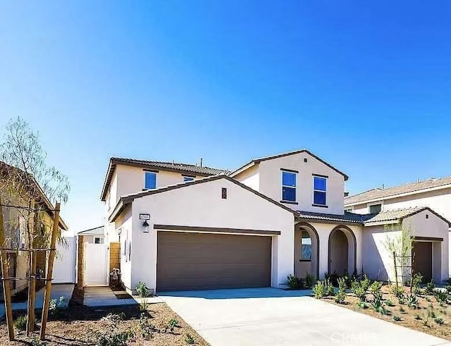 traditional-style home featuring stucco siding, concrete driveway, an attached garage, fence, and a tile roof