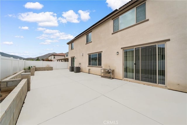 6506 Zion Way, Jurupa Valley, CA 92509 - rear view of property featuring a patio, stucco siding, a fenced backyard, and central AC