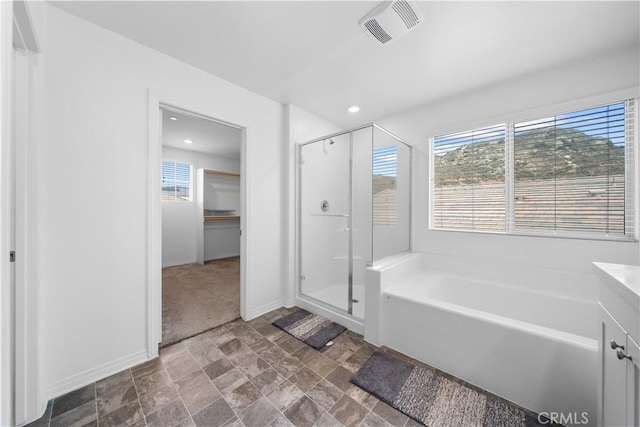 6506 Zion Way, Jurupa Valley, CA 92509 - bathroom with a shower stall, baseboards, a bath, stone finish flooring, and a spacious closet