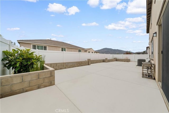 6506 Zion Way, Jurupa Valley, CA 92509 - view of patio with cooling unit, a fenced backyard, and a mountain view