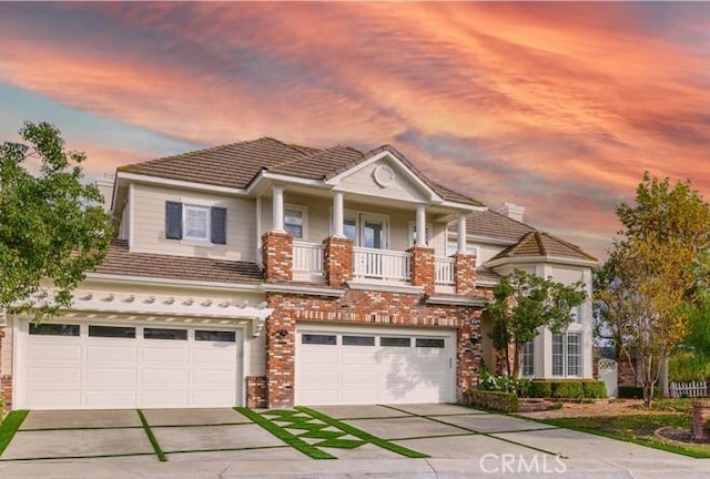 view of front of property featuring an attached garage, a tiled roof, brick siding, and driveway
