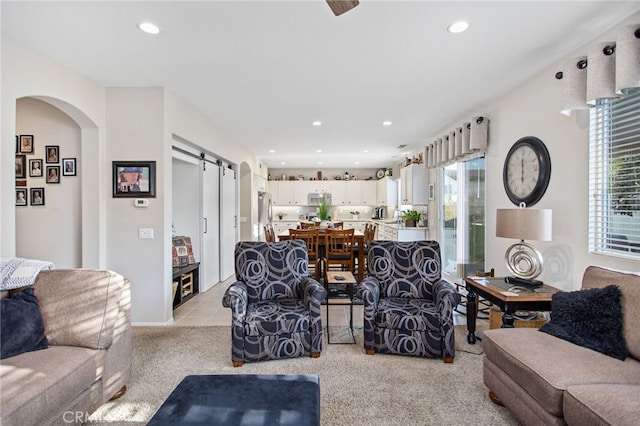 6347 Lyndsey St, Eastvale, CA 92880 - living area featuring recessed lighting, a barn door, arched walkways, and light carpet