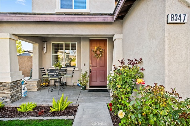 6347 Lyndsey St, Eastvale, CA 92880 - view of exterior entry with a patio, outdoor dining space, and stucco siding