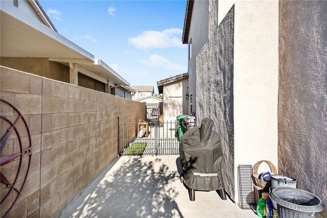 6347 Lyndsey St, Eastvale, CA 92880 - view of property exterior with stucco siding, a gate, a patio area, and fence
