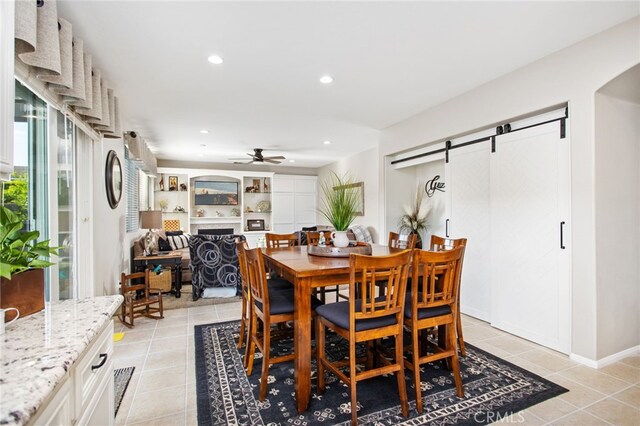 6347 Lyndsey St, Eastvale, CA 92880 - dining space featuring light tile patterned flooring, a fireplace, recessed lighting, a barn door, and a ceiling fan
