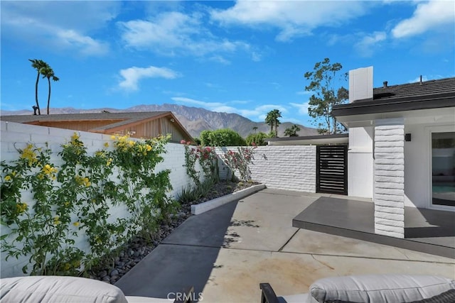 view of patio with a mountain view and a fenced backyard