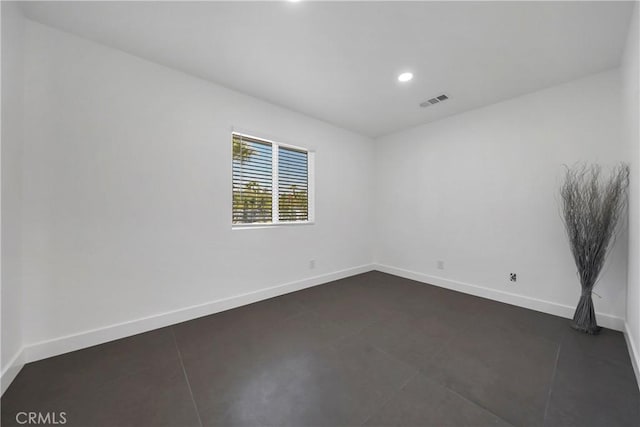 spare room featuring visible vents, recessed lighting, baseboards, and dark tile patterned flooring