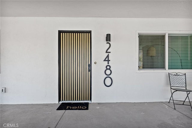 entrance to property with stucco siding