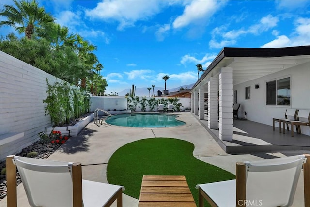 view of swimming pool with a patio, a fenced in pool, and a fenced backyard