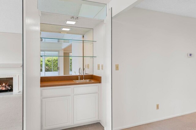 1109 Calle Del Baston, San Marcos, CA 92078 - indoor wet bar featuring light colored carpet and a warm lit fireplace