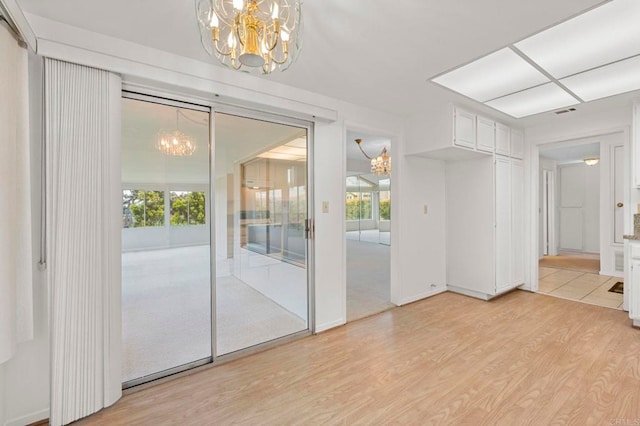 1109 Calle Del Baston, San Marcos, CA 92078 - unfurnished room featuring a chandelier, light wood finished floors, and healthy amount of natural light
