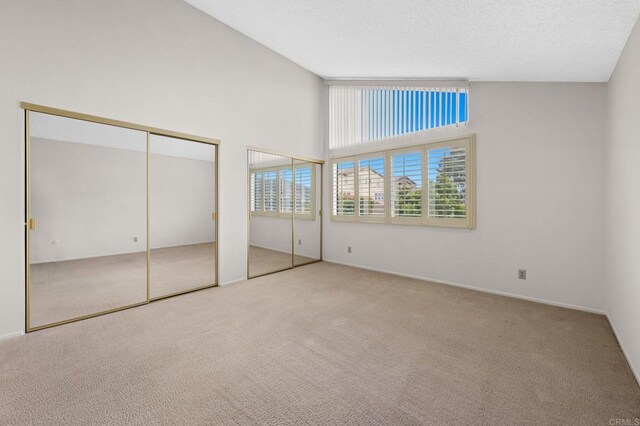1109 Calle Del Baston, San Marcos, CA 92078 - unfurnished bedroom with carpet flooring, multiple closets, and a towering ceiling