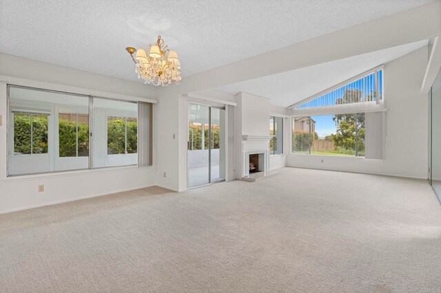 1109 Calle Del Baston, San Marcos, CA 92078 - unfurnished living room with a chandelier, carpet, a fireplace with raised hearth, a textured ceiling, and lofted ceiling