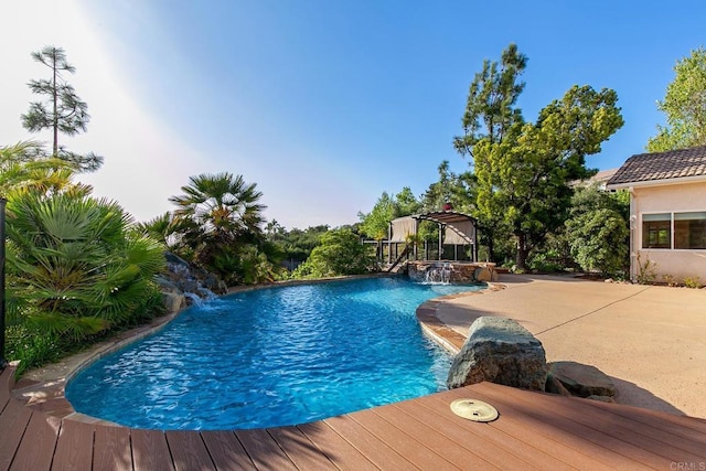 pool with an outdoor hot tub and a patio area