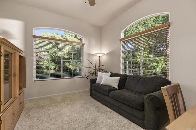 carpeted living room with baseboards and ceiling fan