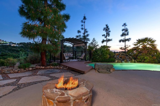 view of patio / terrace with a fenced in pool, an outdoor fire pit, a pergola, and a deck