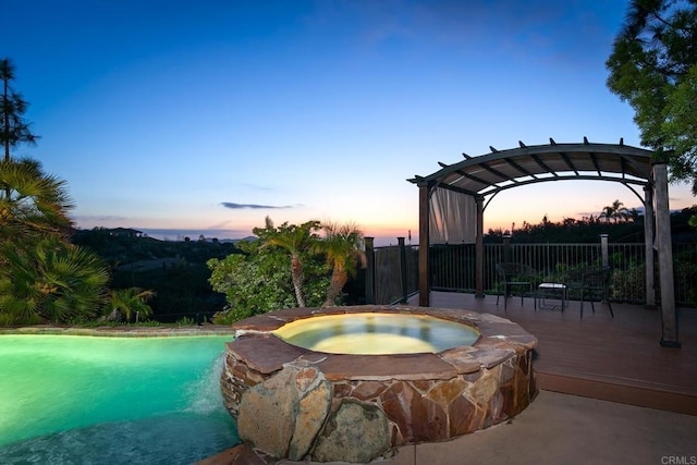 view of pool with a deck, an in ground hot tub, and a pergola