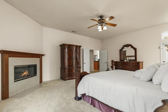 bedroom featuring a fireplace, ceiling fan, light carpet, and visible vents