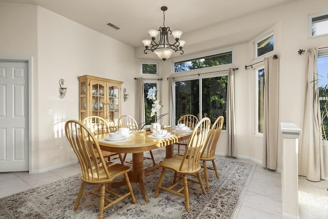 dining room featuring light tile patterned flooring, baseboards, a notable chandelier, and visible vents