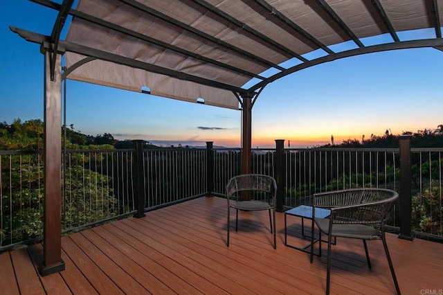 deck at dusk featuring a pergola