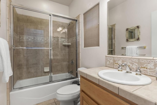 full bath featuring decorative backsplash, tile patterned floors, bath / shower combo with glass door, vanity, and toilet