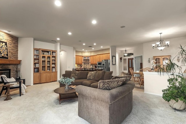 living room with baseboards, recessed lighting, a stone fireplace, and light colored carpet
