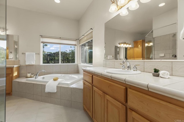 bathroom featuring a garden tub, tile patterned flooring, vanity, a notable chandelier, and recessed lighting
