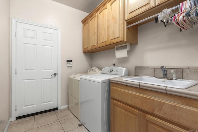 laundry area with independent washer and dryer, cabinet space, a sink, baseboards, and light tile patterned flooring