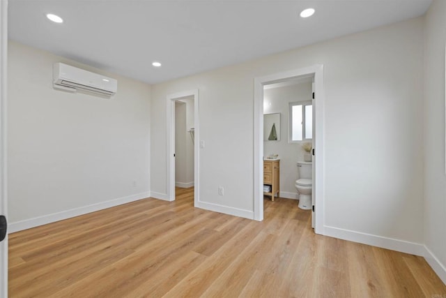 5061 Canosa Ave, San Diego, CA 92117 - unfurnished bedroom with a wall mounted AC, recessed lighting, baseboards, ensuite bath, and light wood-style flooring