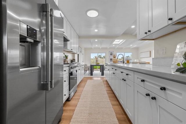 5061 Canosa Ave, San Diego, CA 92117 - kitchen with beam ceiling, light wood-type flooring, light countertops, white cabinetry, and appliances with stainless steel finishes