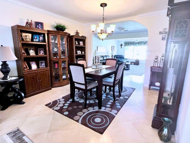 dining room with arched walkways, a chandelier, ornamental molding, and light tile patterned floors