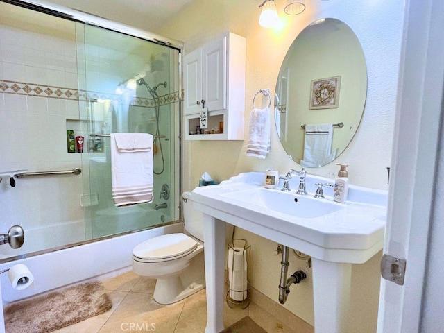 full bathroom with tile patterned flooring, enclosed tub / shower combo, and toilet