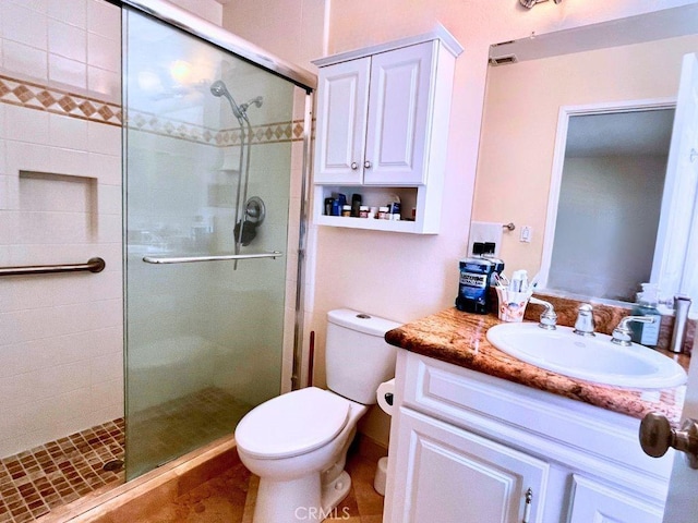 full bathroom with vanity, a shower stall, toilet, and visible vents